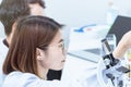 Young female scientist student mixing substances in test tube.