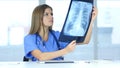 Young Female Serious Doctor Examing X-ray of Patient, Lungs and ribcage Royalty Free Stock Photo