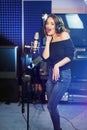 Young female singer recording album in the professional studio. Woman singing a song in music recording studio. Royalty Free Stock Photo