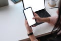 Young female sitting at comfortable workspace working with tablet and using smart phone.