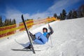 Young female skier after the fall on mountain slope Royalty Free Stock Photo