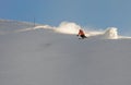 A young female skier in an orange jacket turns carving arches on the slope. A beautiful sunny day in the mountains, on the ski Royalty Free Stock Photo