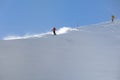 A young female skier in an orange jacket turns carving arches on the slope. A beautiful sunny day in the mountains, on the ski Royalty Free Stock Photo