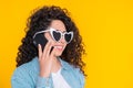 Young female smiling and talking on mobile phone over yellow background. Beautiful mixed race girl holding and using Royalty Free Stock Photo