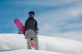 Young female snowboarder standing on the mountain slope