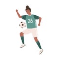 Young female soccer player kicking ball. African American woman playing football in green sports uniform, boots and