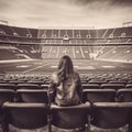 Young female spectator enjoying a view of an empty sports stadium