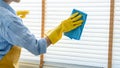Young female spring cleaning house interior holding a duster for wiping dust dusting furniture at home