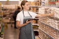 Young female staff using digital tablet in supermarket. Royalty Free Stock Photo