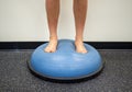 Young female standing on a bosu ball for a workout