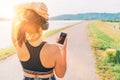 Young female starting jogging and listening to music using smartphone and wireless headphones