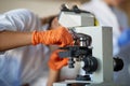 A young female student adjusts a microscope in a laboratory. Science, chemistry, lab, people Royalty Free Stock Photo