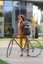 Young female student with backpack and books riding a retro bicycle.Female on retro bicycle. Royalty Free Stock Photo