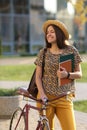 Young female student with backpack and books riding a retro bicycle. Female on retro bicycle. Royalty Free Stock Photo