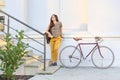 Young female student with backpack and books riding a retro bicycle. Royalty Free Stock Photo