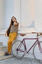 Young female student with backpack and books riding a retro bicycle. Royalty Free Stock Photo