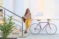 Young female student with backpack and books riding a retro bicycle. Royalty Free Stock Photo