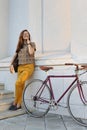 Young female student with backpack and books riding a retro bicycle. Royalty Free Stock Photo