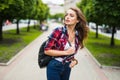 Young female student with backpack walking in the park Royalty Free Stock Photo