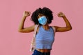 young female student with backpack wearing protective mask and posing on pink background, back to school concept Royalty Free Stock Photo