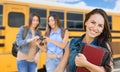 Young Female Student with Books Near School Bus