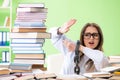 The young female student chained to the desk and preparing for exams with many books Royalty Free Stock Photo