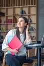 Young female student in front of a laptop in the library. Royalty Free Stock Photo