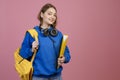 Young female student holding yellow rucksack and folder, smiling. Royalty Free Stock Photo
