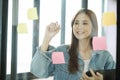 Young female student writing study plans on post-its on glass wall. Royalty Free Stock Photo