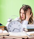 Young female student preparing for exams with many books in time Royalty Free Stock Photo