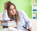 Young female student preparing for exams with many books Royalty Free Stock Photo
