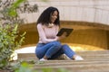 Young female student sitting on some stairs looking at a digital tablet Royalty Free Stock Photo