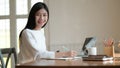 Young female student take notes and use laptop to search for research to prepare for graduation