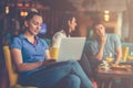 Young female student is using laptop computer in cafe Royalty Free Stock Photo