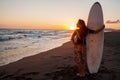 Young female surfer on beach in sunset Royalty Free Stock Photo