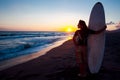 Young female surfer on beach in sunset Royalty Free Stock Photo