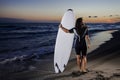 Young female surfer on beach in sunset Royalty Free Stock Photo