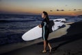 Young female surfer on beach in sunset Royalty Free Stock Photo