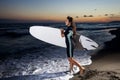 Young female surfer on beach in sunset Royalty Free Stock Photo