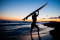 Young female surfer on beach in sunset Royalty Free Stock Photo