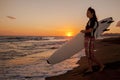 Young female surfer on beach in sunset Royalty Free Stock Photo