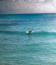 Female surfer riding surf wave in Caribbean waters off the coast of tropical island Barbados