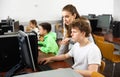 Female teacher helping focused teenage student in computer lab Royalty Free Stock Photo