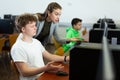 Female teacher helping focused teenage student in computer lab Royalty Free Stock Photo