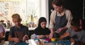 Young female teacher helps student mold clay during class