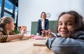 young female teacher looking at multiethnic schoolchildren Royalty Free Stock Photo