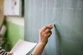 Young female teacher or a student writing math formula on blackboard. Royalty Free Stock Photo