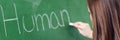 Young female teacher teaching in biology class. Teacher writing Human Body on blackboard using chalk. Royalty Free Stock Photo