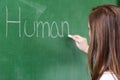 Young female teacher teaching in biology class. Teacher writing Human Body on blackboard. Royalty Free Stock Photo