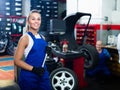 female technician standing with wheel balancing machinery at auto workshop Royalty Free Stock Photo